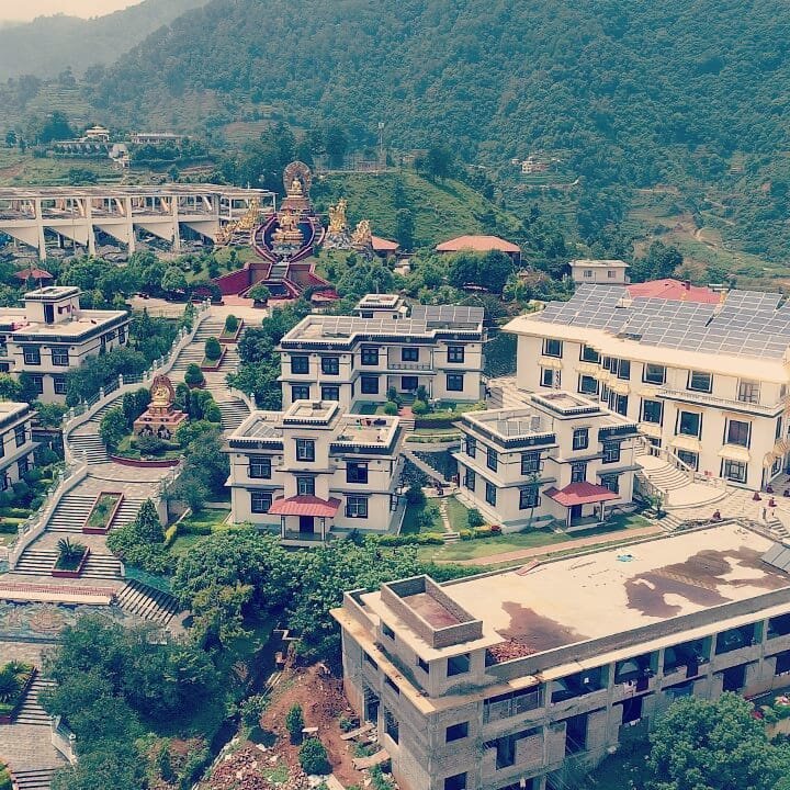 Aerial view of the Druk Amitabha Mountain compound with rooftop solar arrays
