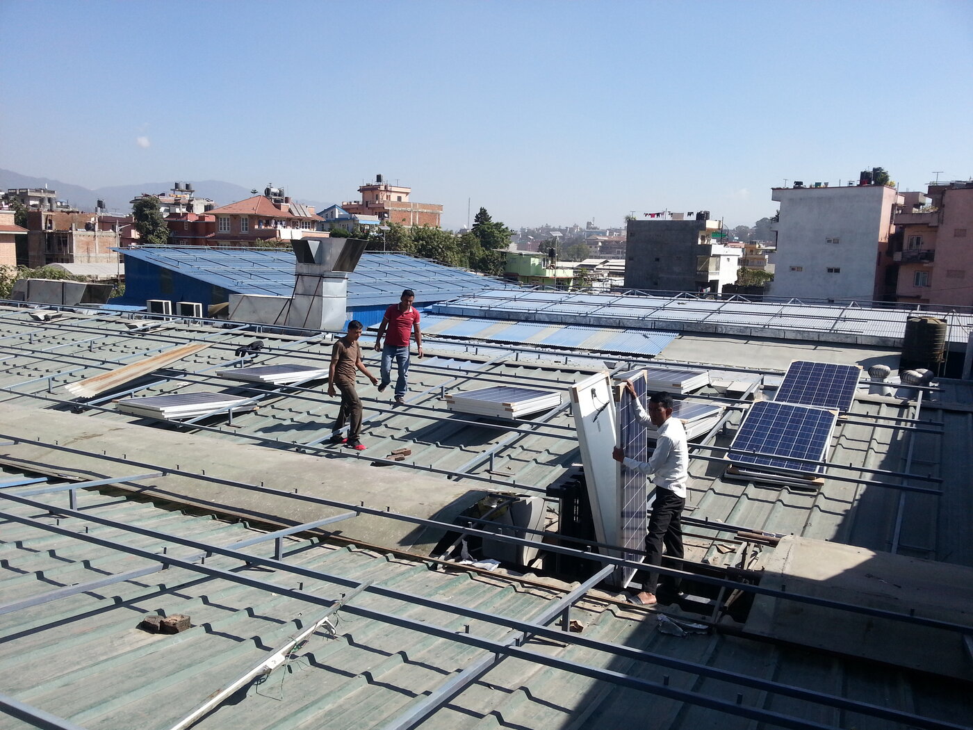 Solar panel installation in progress on the factory roof